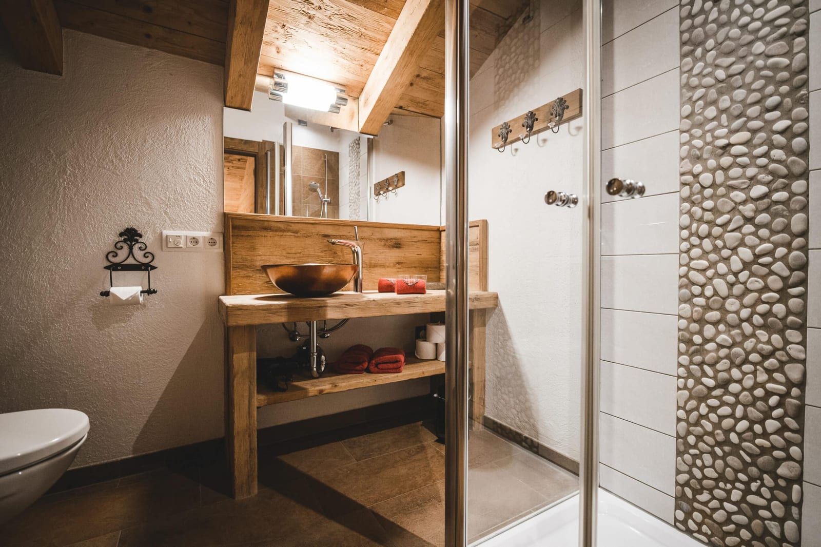 Kuschelecke mit Kaminofen und warmen Rottönen im Romanze-Chalet